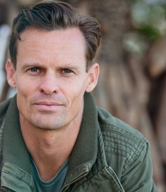 Close-up portrait of a man wearing a casual jacket outdoors.